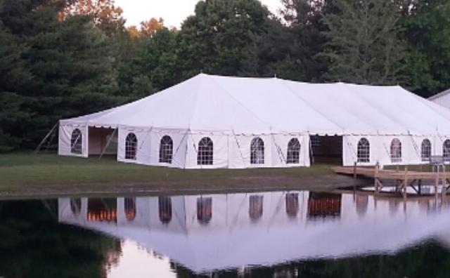 40 ft. x 100 ft. Celina Pole Tent by a Pond and Barn